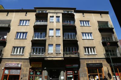 Frontalne ujęcie elewacji ukazujące zr&oacute;żnicowanie fakturalne jej płaszczyzn architektonicznych uzyskane dzięki zastosowaniu trzech odmian tynk&oacute;w szlachetnych. Parter wyr&oacute;żniony jest tynkiem kamieniarskim imitującym tradycyjne boniowanie, wyższe kondygnacje wykończono tynkiem gładkim, natomiast obręb wejścia szlifowanym na gładko  lastrikiem. Zdjęcie ze zbior&oacute;w Biura Miejskiego Konserwatora Zabytk&oacute;w UM Rzeszowa